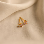 Pink Baguette Opal Studs with shimmering pink gemstones rest on soft beige fabric—ideal elegant bridal gifts.