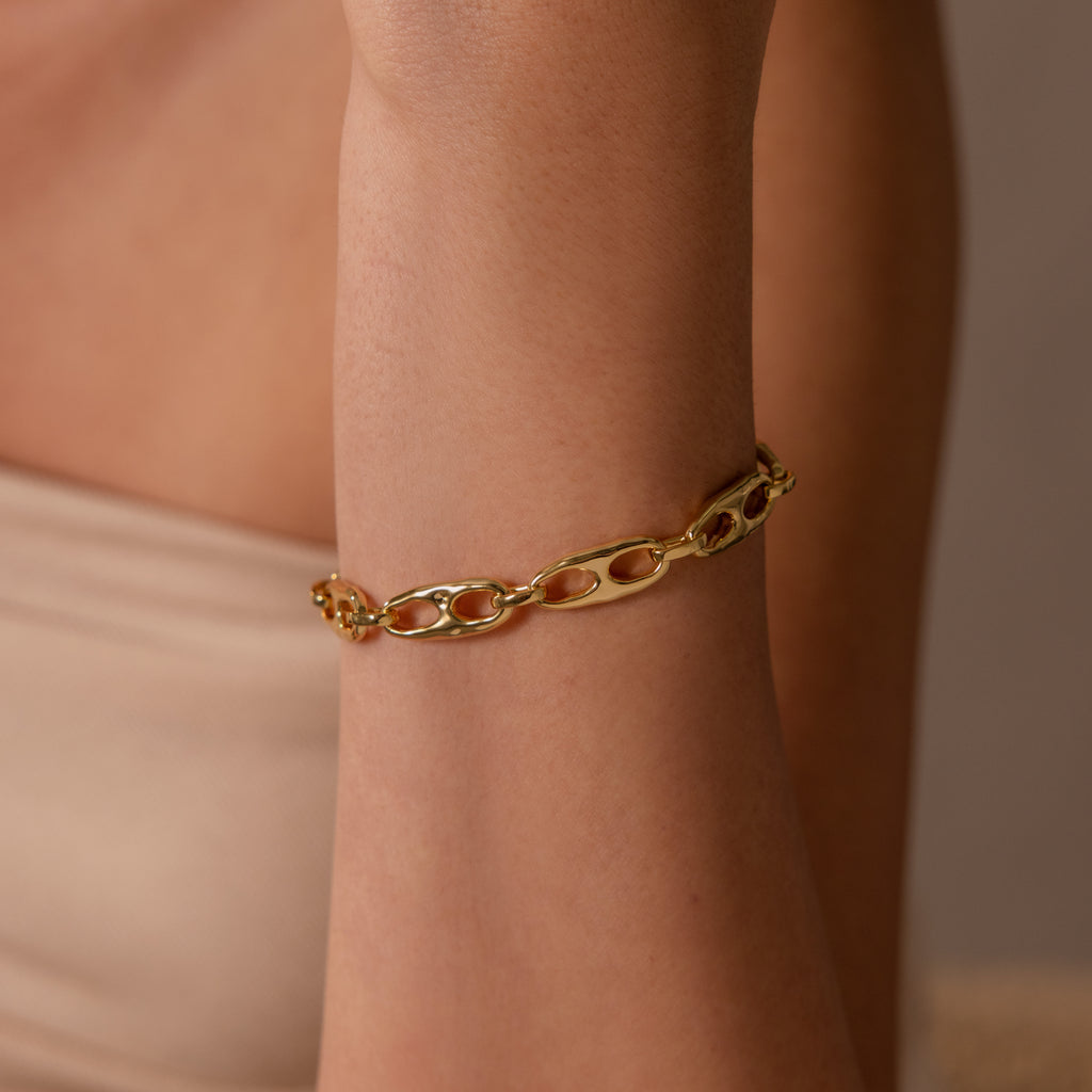 A close-up of the Organic Mariner Chain Bracelet on a bare arm with a beige background, ideal for lovers of contemporary jewelry.