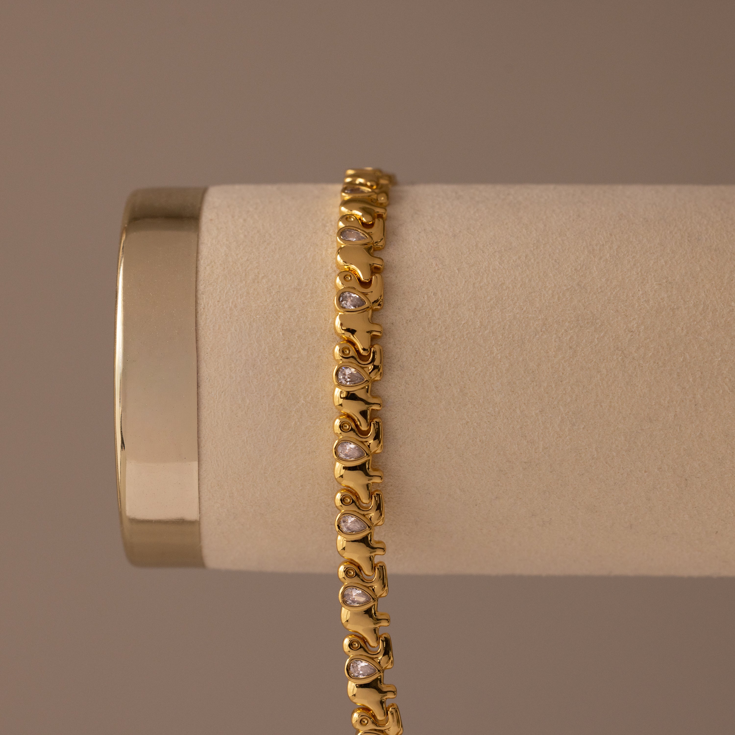 Diamond Elephant Link Bracelet featuring an intricate design with embedded white stones, displayed elegantly on a beige cylindrical holder.