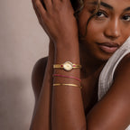 Exuding retro glamour, the woman wears the Art Deco Ruby Timepiece on her wrist, resting her arm on her face as she gazes at the camera.
