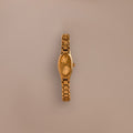 The Slim Oval Timepiece gold wristwatch with a polished link bracelet is shown against a plain beige background.