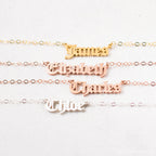 Four Old English Name Necklaces in gold, rose gold, and silver display the names James, Elizabeth, Charles, and Chloe—each a personalized charm.
