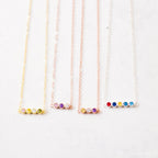 Four delicate chain necklaces, each with four colorful gemstone beads, displayed side by side—Multiple Birthstone Necklace, the perfect personalized gift for new moms or anyone wanting a meaningful custom birthstone necklace.