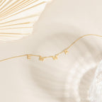 Custom Letter Necklace with gold charms spelling EMMA shown on a neutral background—an ideal personalized jewelry piece for any style.
