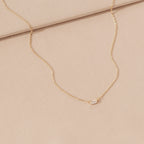 Delicate sterling silver Emery Necklace with a small rectangular pendant on a soft beige fabric—a perfect minimal accessory and thoughtful holiday gift.