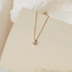 Rae Diamond Necklace with solitaire diamond on delicate 18K gold chain displayed on beige card.