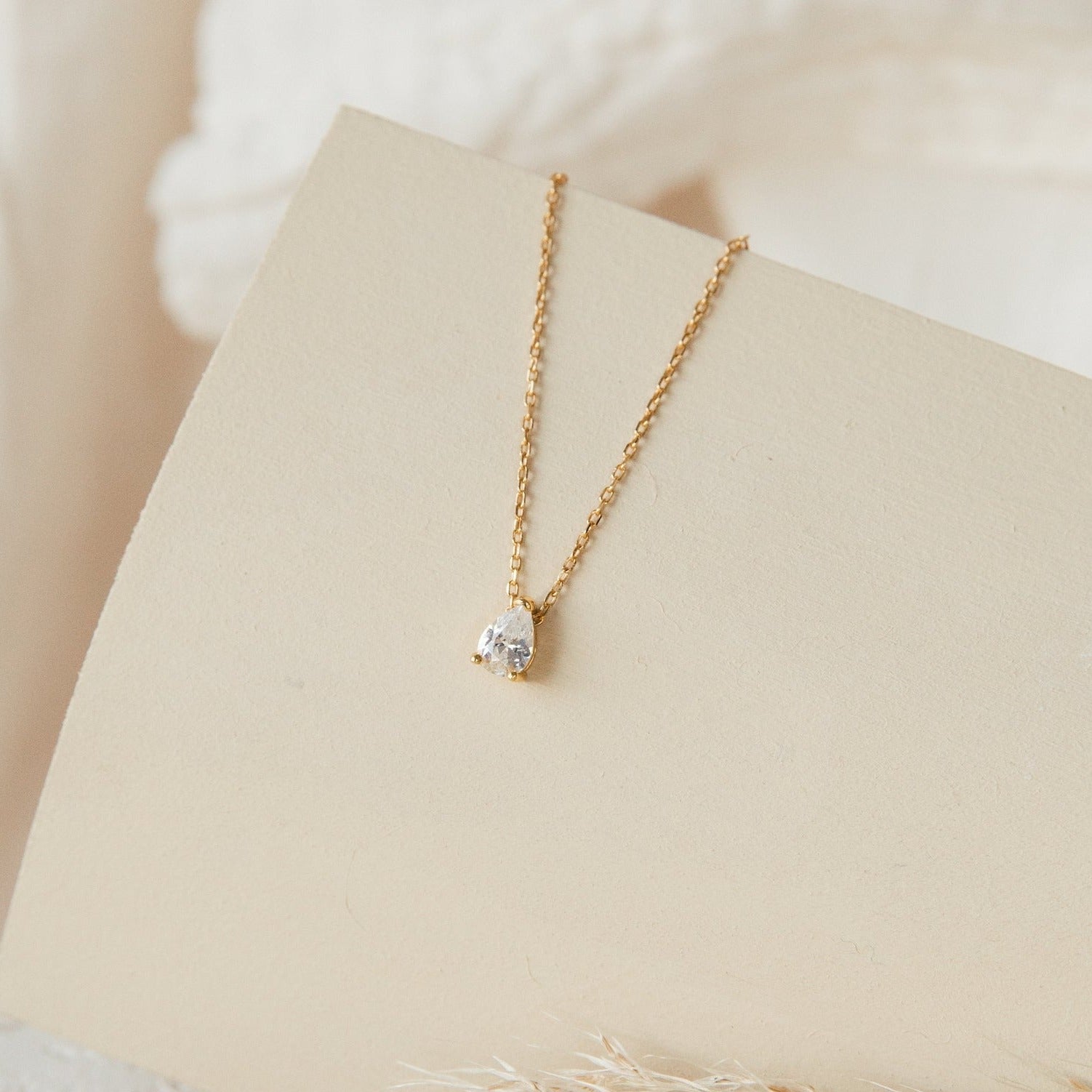 Rae Diamond Necklace with solitaire diamond on delicate 18K gold chain displayed on beige card.
