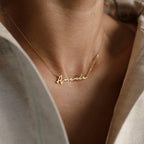 The Venice Name Necklace showcases the name "Amanda" in elegant script, creating a delicate accessory that's perfect to wear with a light-colored shirt.
