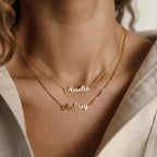 Close-up of two gold Mellow Name Necklaces with "Amelia" and "Aubrey" on a woman's neck, highlighting the elegance and personalization of the Mellow Name Necklace.