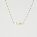 The Mellow Name Necklace features a gold chain and a pendant spelling "Amelia" in elegant cursive, making it an ideal personalized necklace for any special occasion.