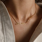 The Venice Name Necklace in Box Chain features "Stella" in elegant cursive on a delicate chain, worn gracefully around the neck.