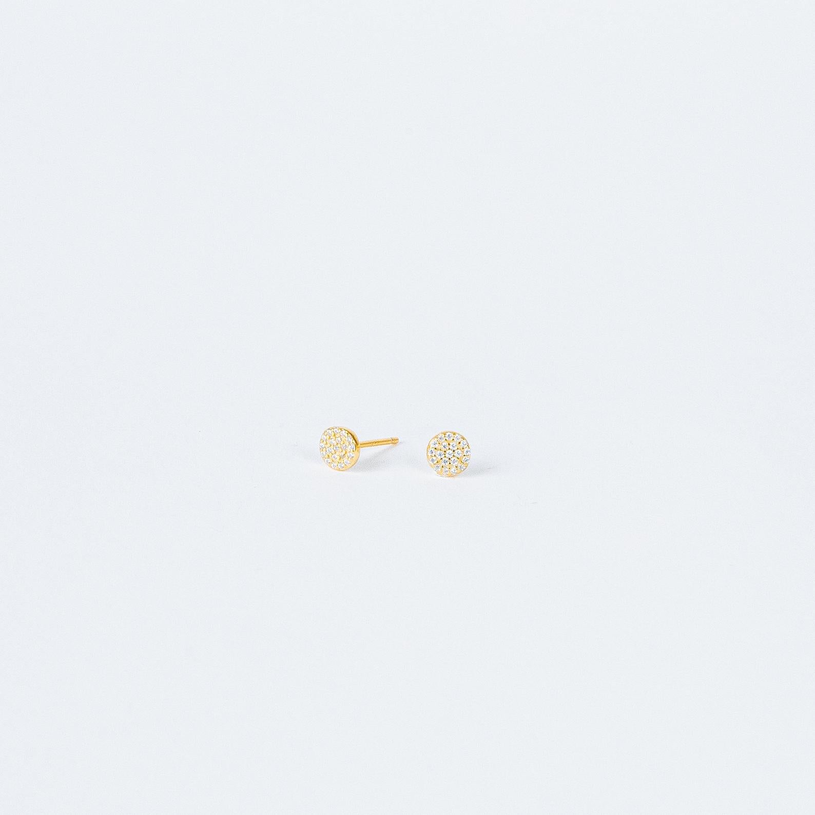 Pave Round Studs feature small, round gold settings encrusted with sparkling crystals, adding a touch of glam to any look on a plain white background.