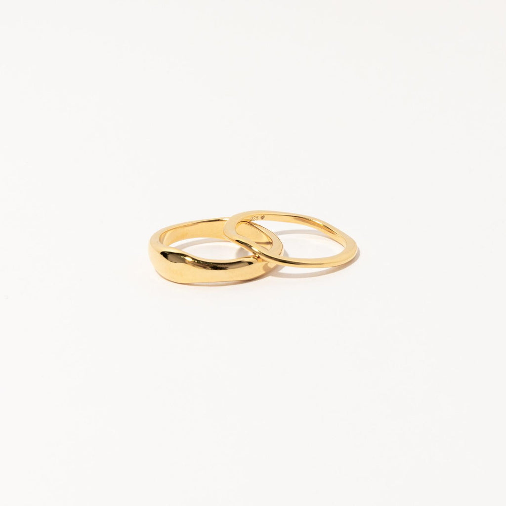 Two interlocking gold rings from the Duo Form Ring Set displayed on a clean white background.