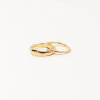 Two interlocking gold rings from the Duo Form Ring Set displayed on a clean white background.