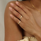A hand adorned with the Gina Pave Signet Ring gently rests on the opposite shoulder, complementing neutral-toned clothing.