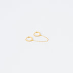 The Pave Duo Chain Earrings feature two small gold huggies linked by a delicate chain, with one hoop embellished with clear stones—perfect for styling with multiple ear piercings.