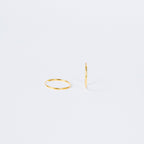Two Thin Hoop Earrings are displayed on a plain white background—one lying flat and one standing upright—highlighting their minimalist style that's perfect for everyday wear.
