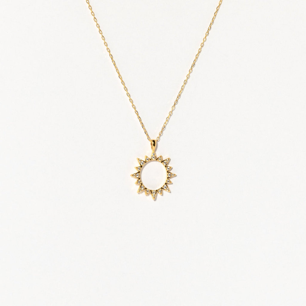 The Pave Sun Necklace features a sun-shaped pendant with pointed rays and subtle pave accents, shown against a plain white background.
