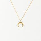 The Crescent Moon Necklace features a gold chain with a delicate crescent moon pendant, shown on a plain white background.