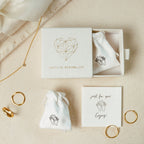 Minimalist jewelry set with rings, a necklace, pouches, and a Caitlyn Minimalist gift box. Complete your look with elegant Amelia Onyx Duo Huggies for a stylish minimalist touch.