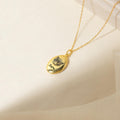 Oval Pet Necklace with an engraved cat face and the name Sam on a soft cream background—a charming personalized pet jewelry piece.