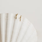 The Rylee Diamond Wire Earrings, a modern pair, displayed elegantly on a white shell.