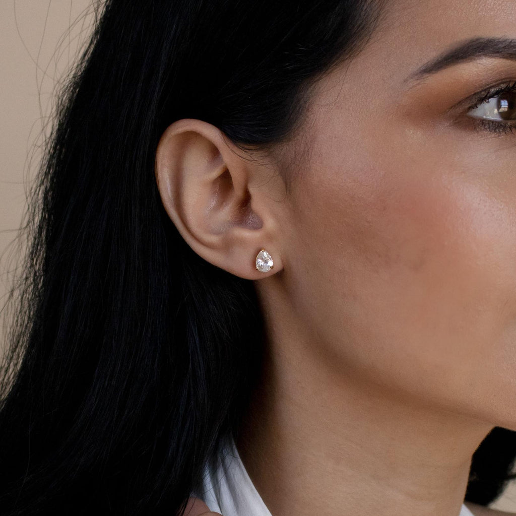 Close-up of a woman's ear wearing minimalistic Pear Diamond Studs—a small, elegant accent adds subtle sophistication.