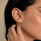 A close-up of a woman's ear wearing Shayla Baguette Huggies, highlighting the elegant baguette-shaped diamond hoop earrings.