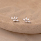 Marquise diamond stud earrings with clustered pear-shaped stones set in 18K gold, displayed on a carved beige stone dish.