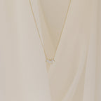 A delicate gold chain necklace featuring a small cluster of marquise-cut clear stones arranged like petals.
