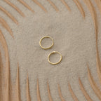 Small Thin Hoops set on textured sand with wavy wood patterns make the perfect simple addition to your everyday jewelry collection.