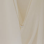 A delicate gold chain necklace featuring a small cluster of marquise-cut clear stones arranged like petals.