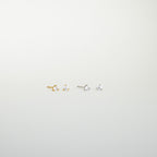 The Elena Diamond Studs set includes two pairs of minimal diamond stud earrings—one gold, one silver—each with a clear gemstone, perfect for elevating your everyday earring collection.