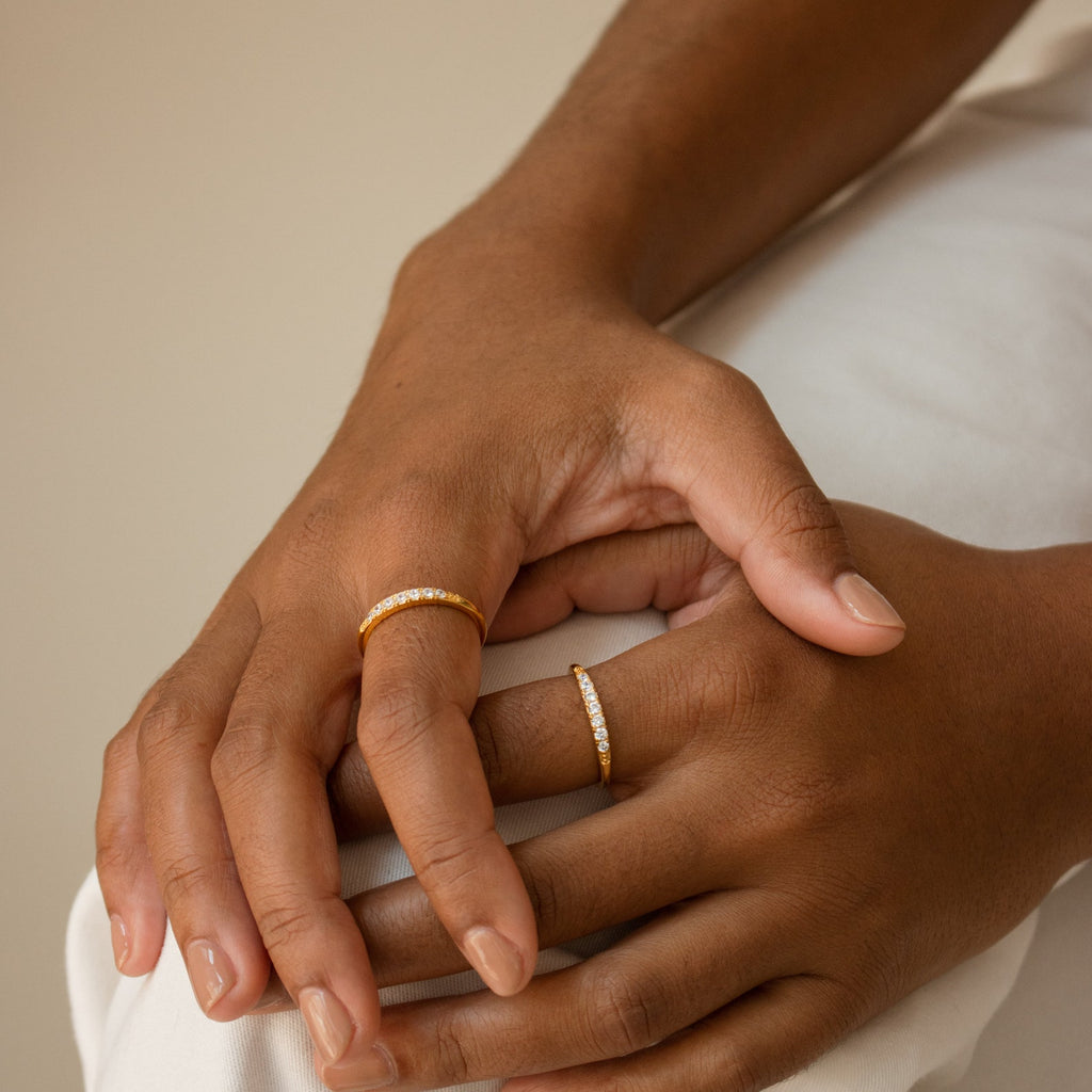 A person's hands adorned with the Lace Pave Ring and other elegant stackable rings on their fingers.
