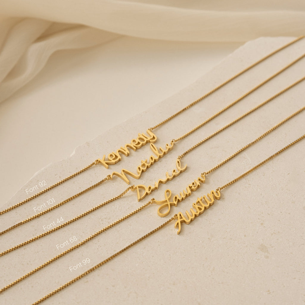 Five Nella Name Necklaces in Box Chain, each with a unique font and personalized with the names Kennedy, Nadia, David, Lauren, and Austin for a modern custom style.