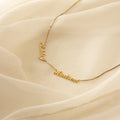 Carrie Multiple Name Necklace in Box Chain, shown with "Ashley" and "Hudson" on a cream sheer fabric background—perfect personalized jewelry for a unique touch.