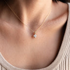 Close-up of a woman wearing the Carina Diamond Necklace, which showcases a gold chain and a sparkling square diamond pendant.