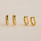 Two pairs of gold hoops, Editor IV 10mm and Editor III Huggies, are displayed on a beige background—ideal for fans of minimalist jewelry.