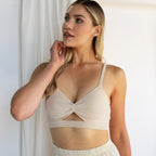 Woman wearing the Kara Body Chain and a beige bralette, styled with trendy jewelry, looks to the side while standing in soft natural light.