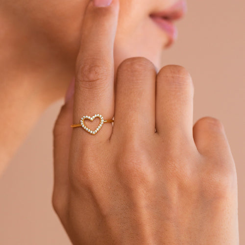 A close-up of a hand wearing the Aphrodite Pave Heart Ring, featuring dazzling diamond stones near the face—an elegant and sparkling choice for an anniversary gift.