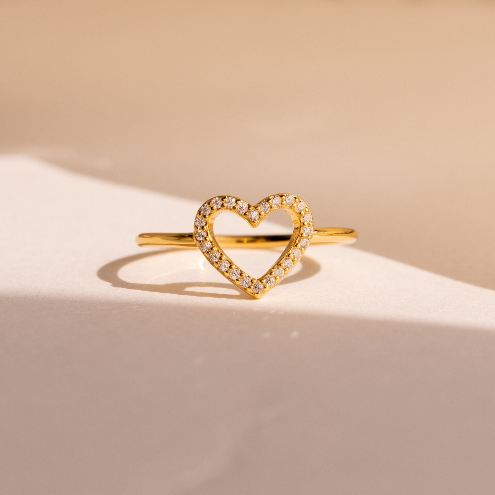The Aphrodite Pave Heart Ring boasts a gold band with an open heart design and shimmering diamonds—an ideal anniversary gift.