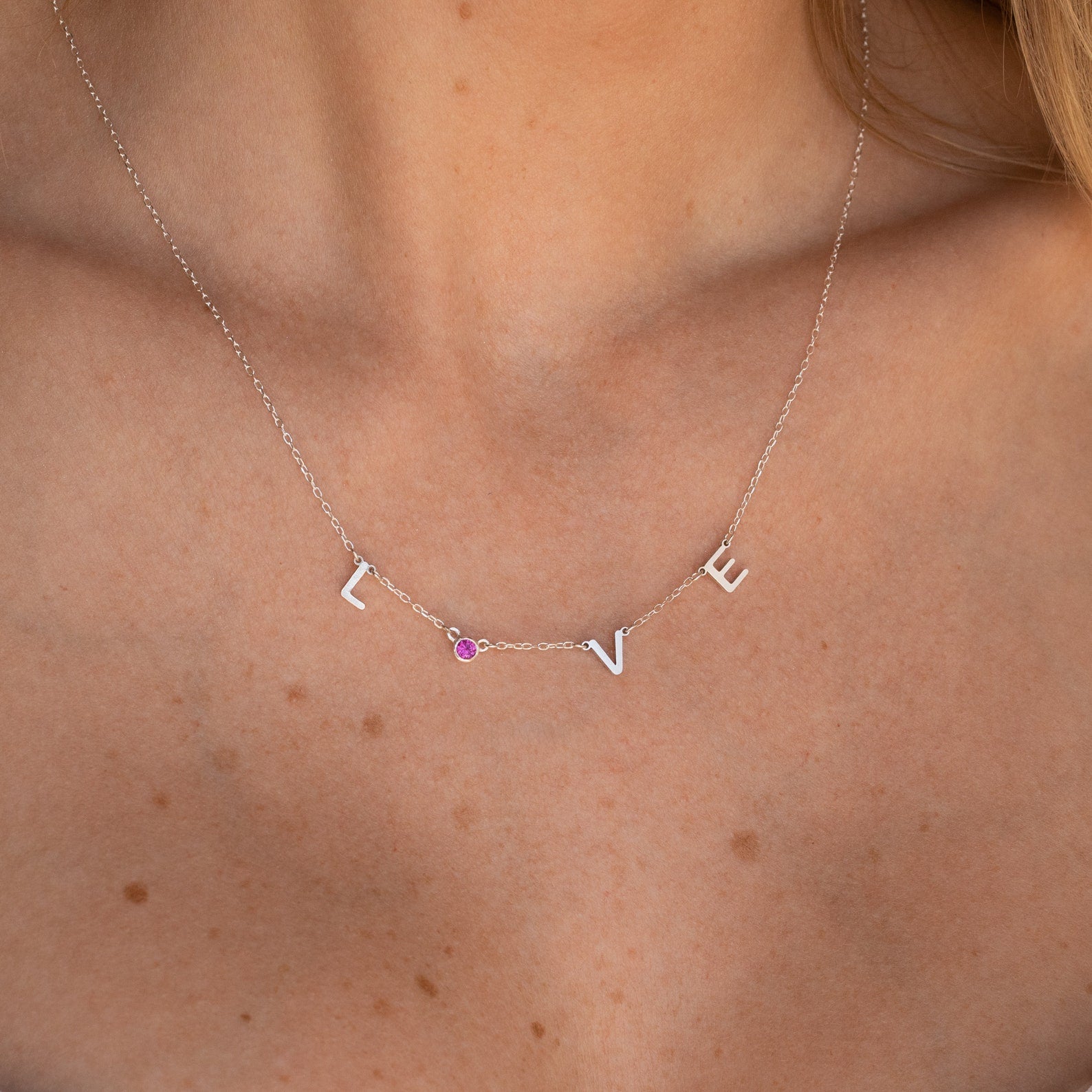 The Alice Letter Birthstone Necklace features dainty letters, a sparkling pink gem, and elegant design—an ideal personalized necklace and thoughtful gift for mom.