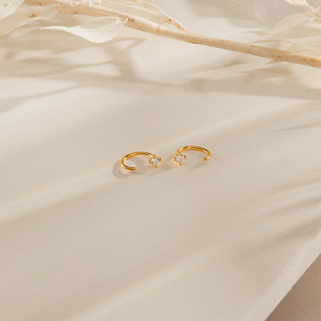 The Saylor II Huggies are delicate hoop earrings adorned with diamonds, ideal for bringing a subtle sparkle to your everyday style.