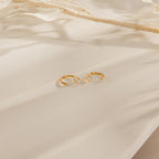 The Saylor II Huggies are delicate hoop earrings adorned with diamonds, ideal for bringing a subtle sparkle to your everyday style.