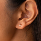 Close-up of an ear wearing a Pave Initial Stud earring shaped like the letter B, adorned with small gemstones—an ideal personalized gift.