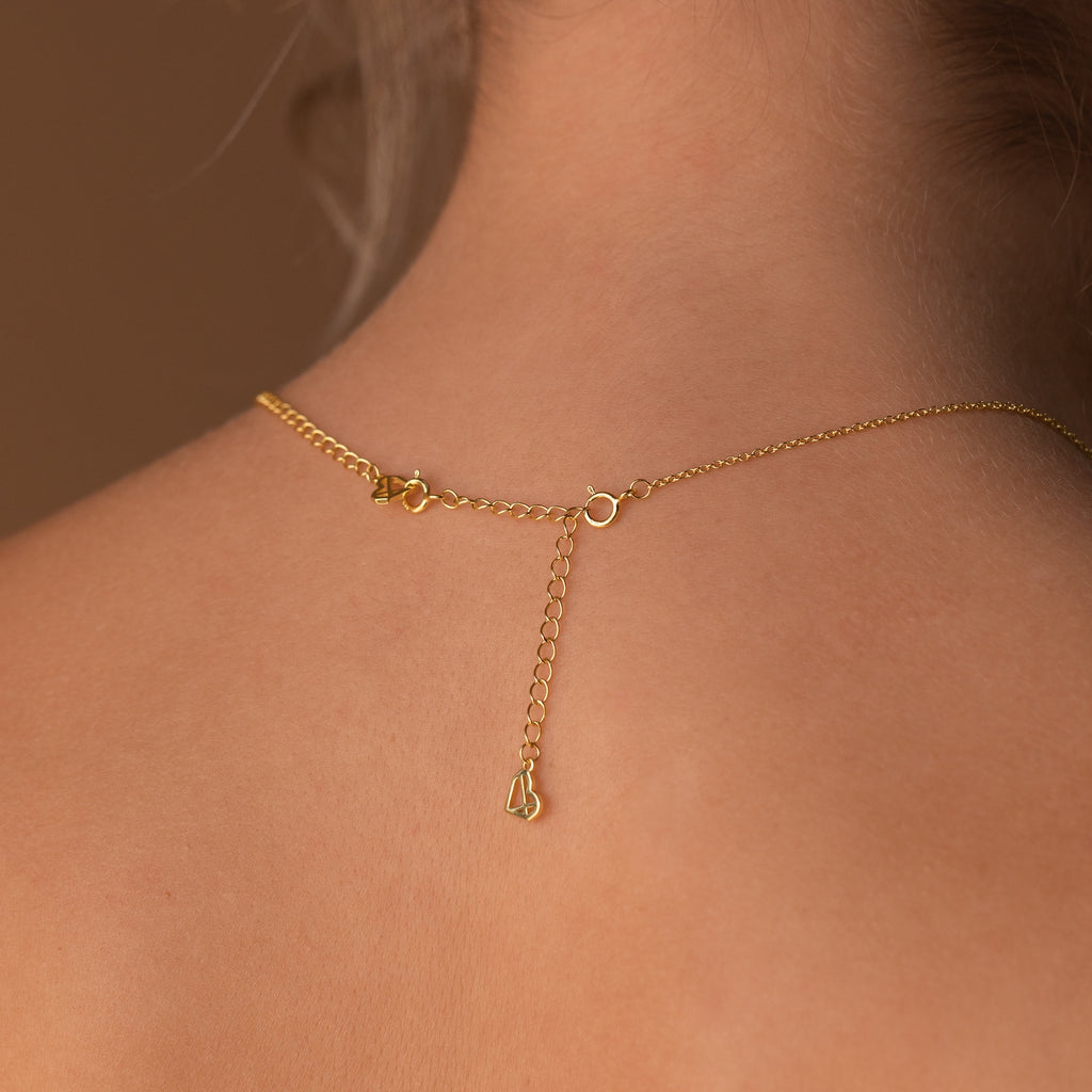 Close-up of a Chain Extender in Sterling Silver, featuring an adjustable extension chain and clasp resting on the back of a person's neck.