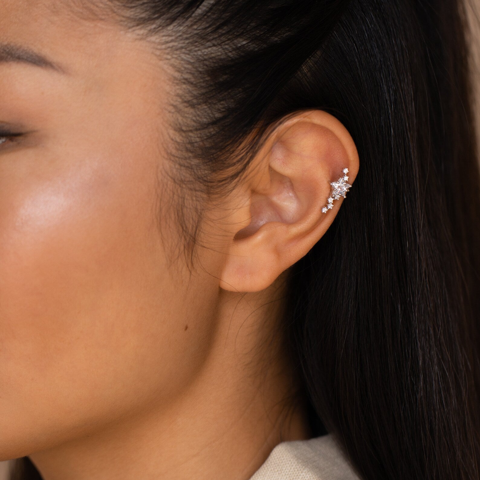 Close-up of a woman's ear wearing Starry Night Ear Cuffs—sparkly silver cuffs with multiple small gemstones, perfect for a stylish look with no piercing needed. Ideal for cuff earring lovers.
