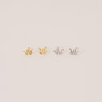 The Tiny Python Studs feature a chic snake design in gold and silver, adding subtle edge to your style. Perfect for boho-luxe earring lovers, these dainty studs are set against a light, neutral backdrop.