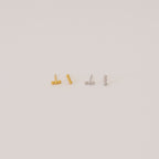 Two pairs of Trio Beaded Bar Studs—one gold, one silver—each featuring three round beads. These minimalist earrings are perfect for everyday wear and are shown against a plain background.