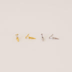 Two pairs of Wren Spike Studs, one gold and one silver, each with a spike-shaped design and lightweight feel, displayed on a light background.